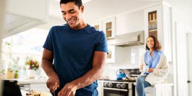 Woman convincing man to cut food while she watches