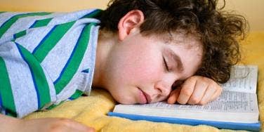 boy sleeping on book