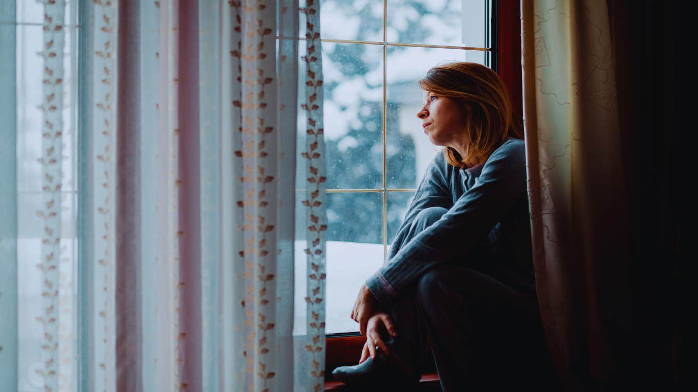 woman sulking by a window
