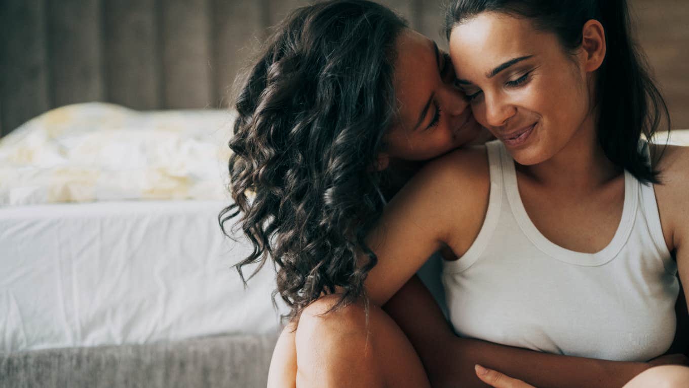 two women embrace each other in hotel room