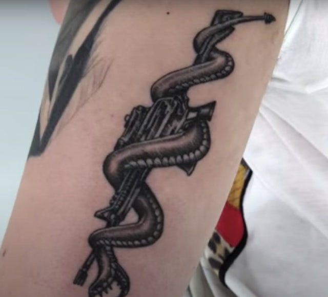 post malone snake coiled around rifle tattoo