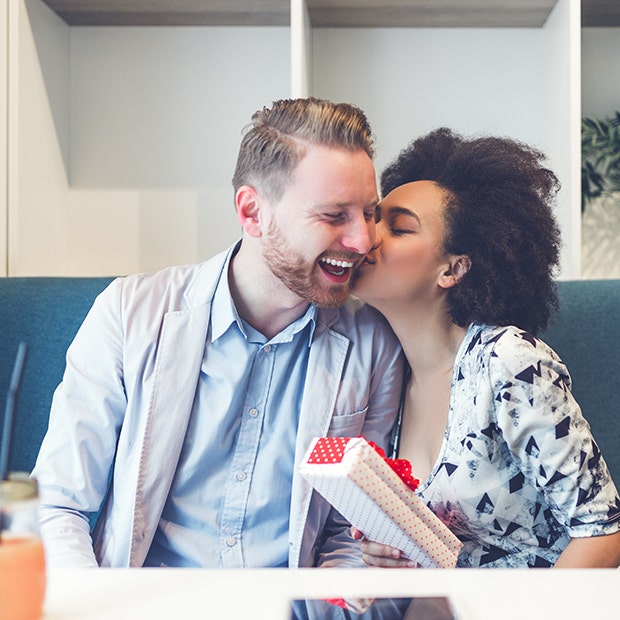 couple kissing woman holding gift