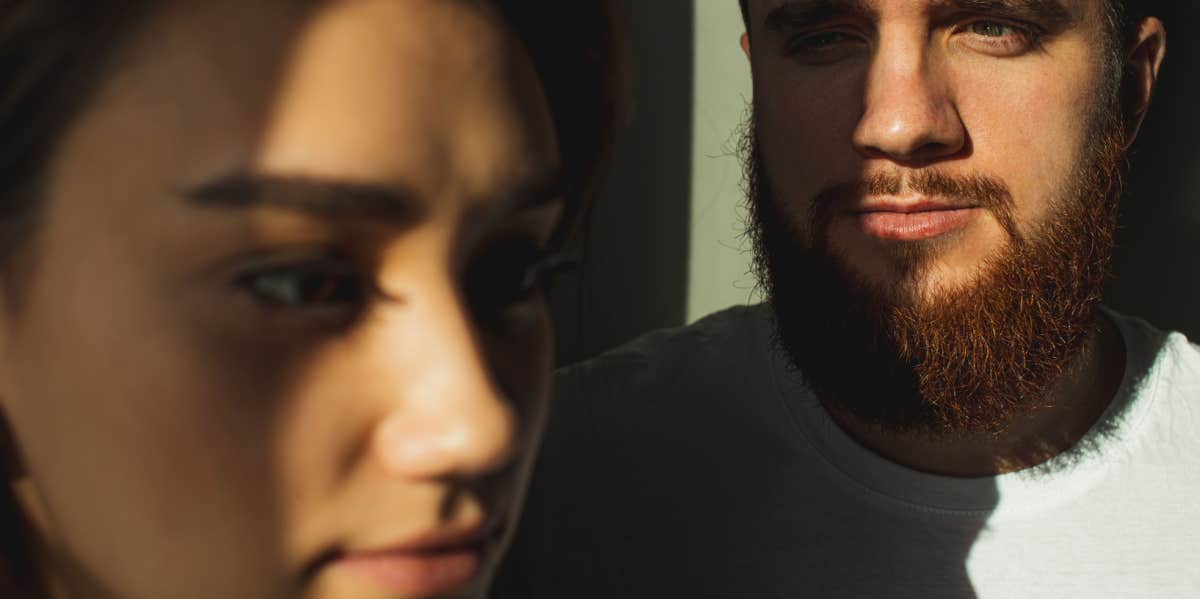 man staring at woman while she looks ahead 