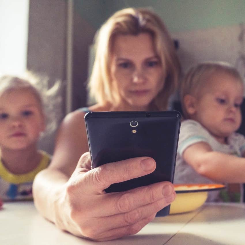 woman on the phone next to two toddlers