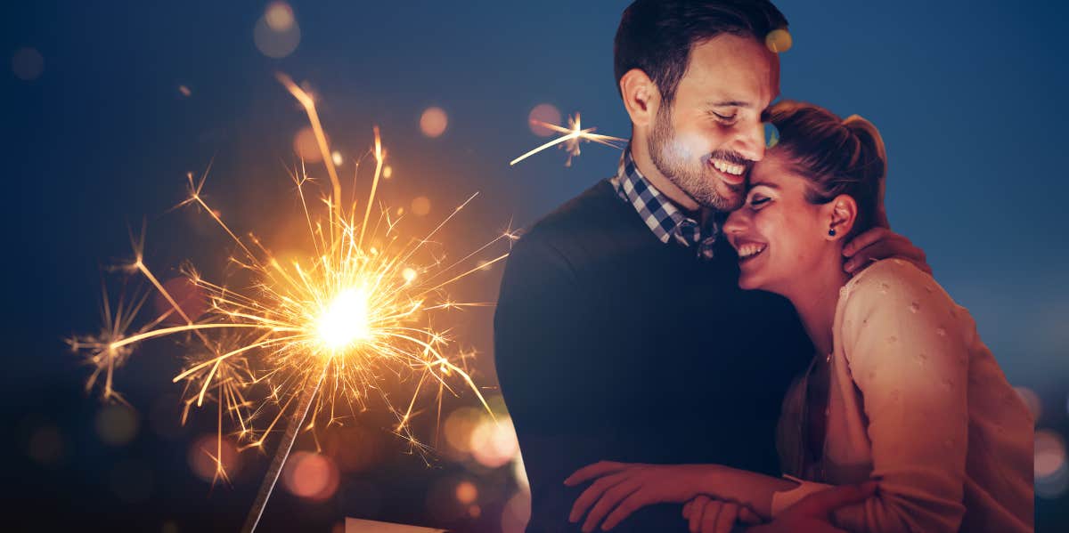 couple sweetly snuggling, sparkler background