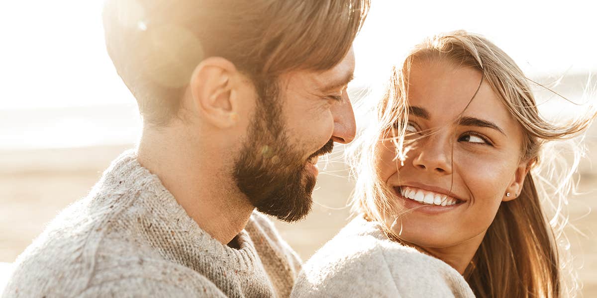 man looking loving at woman at the beach smiling