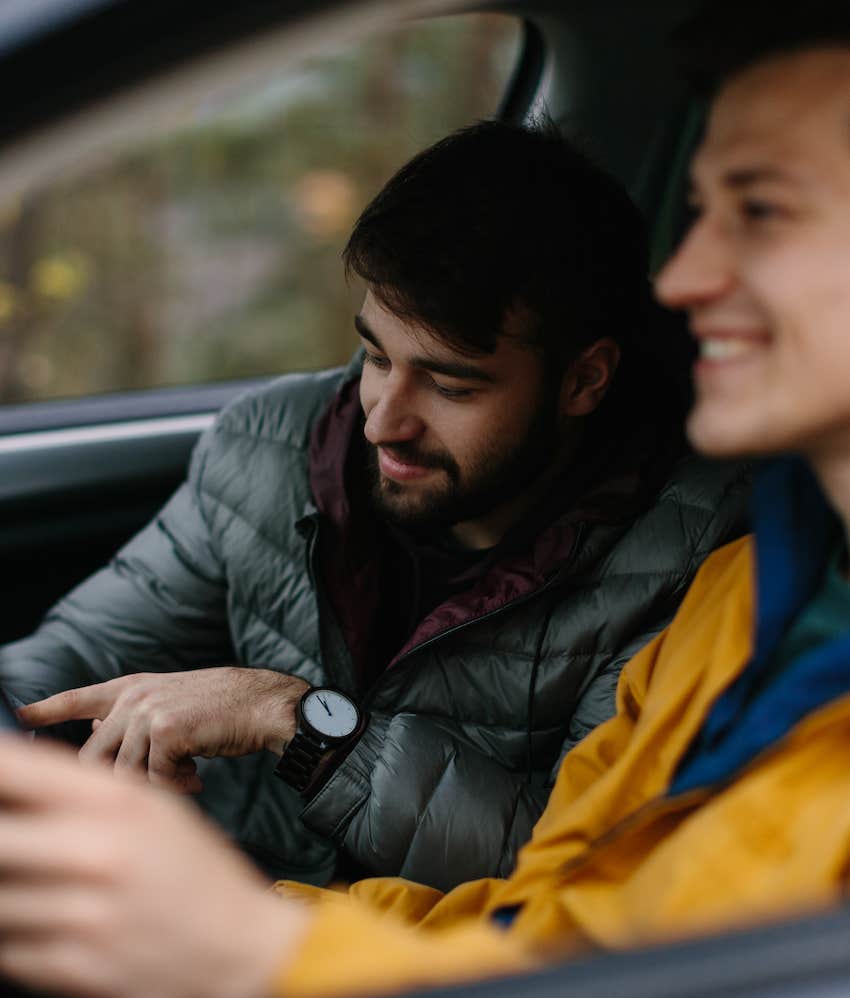 2 men on a road trip smiling and cooperating