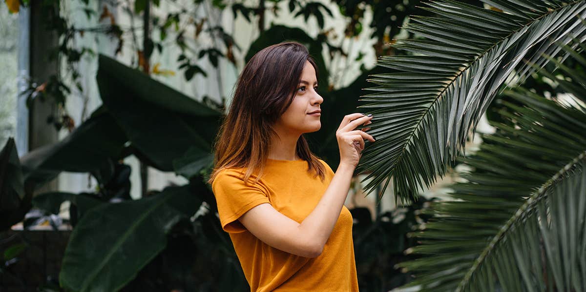 Woman enjoying nature, touching plant