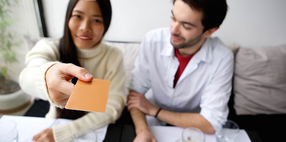 Couple on a date, woman paying for lunch