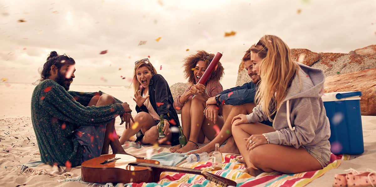 The #1 Thing Every Single One Of Your Friends With Anxiety Wants You To Know Happy friends partying on the beach with drinks and confetti.