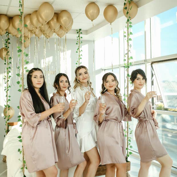 bridesmaids and bride holding champagne