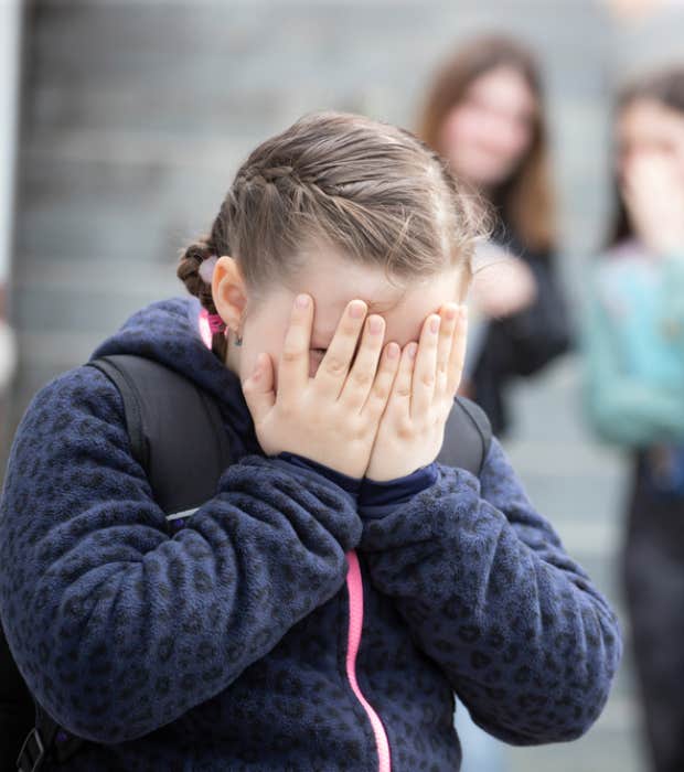 shamed little girl covering her face