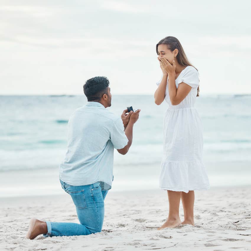 man proposing to woman on the beach