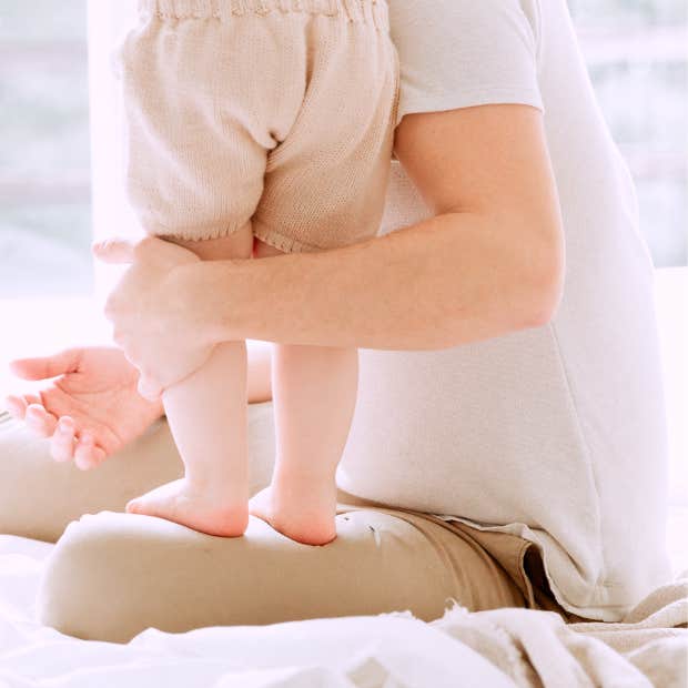 parent holding toddler by the legs
