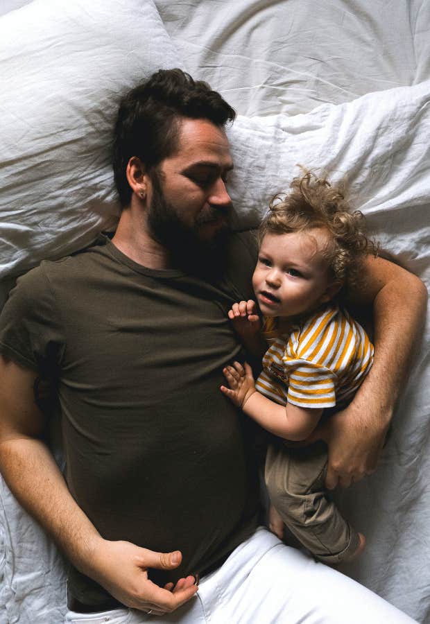 man laying with young son