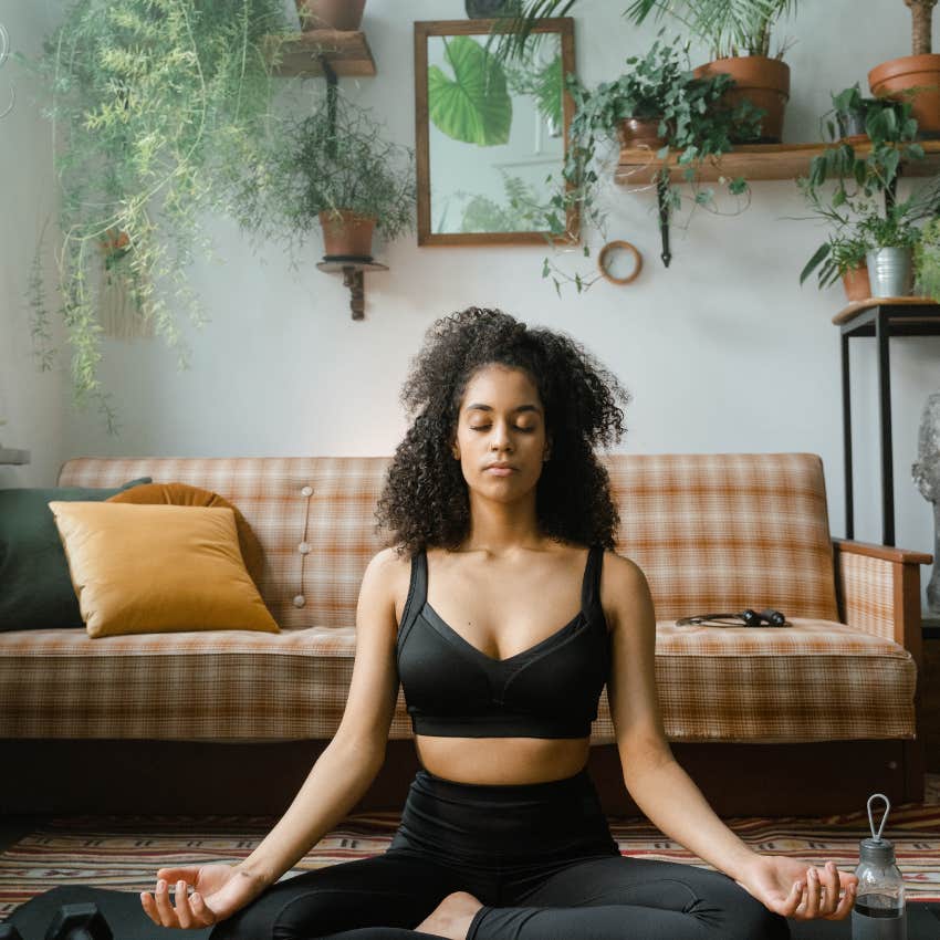 woman meditating in room with plants