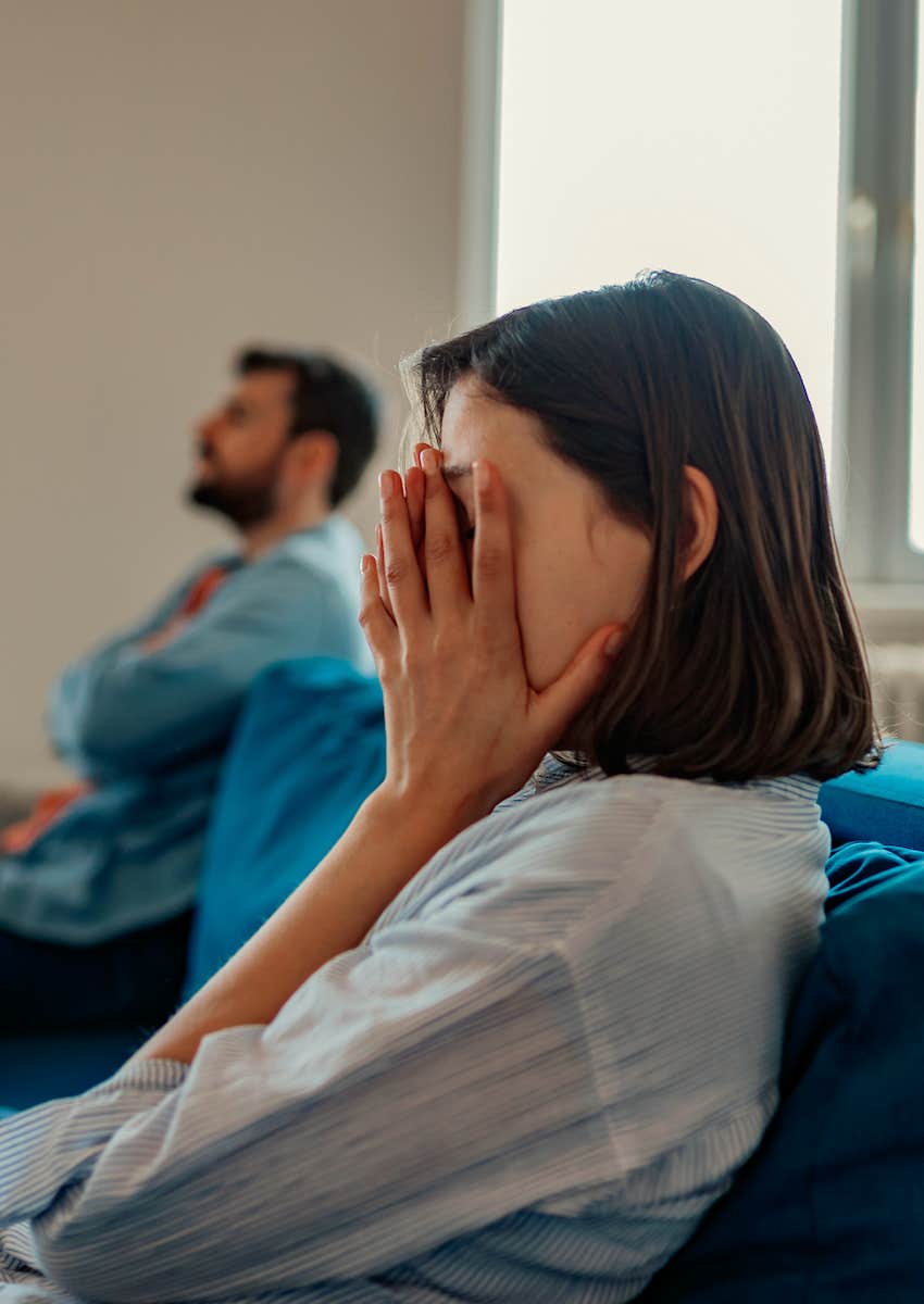 man and woman on opposite end of couch, woman is distraught