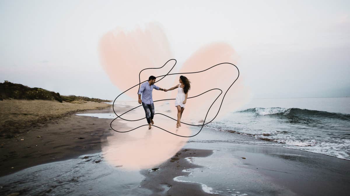 Couple spontaneously running down the beach