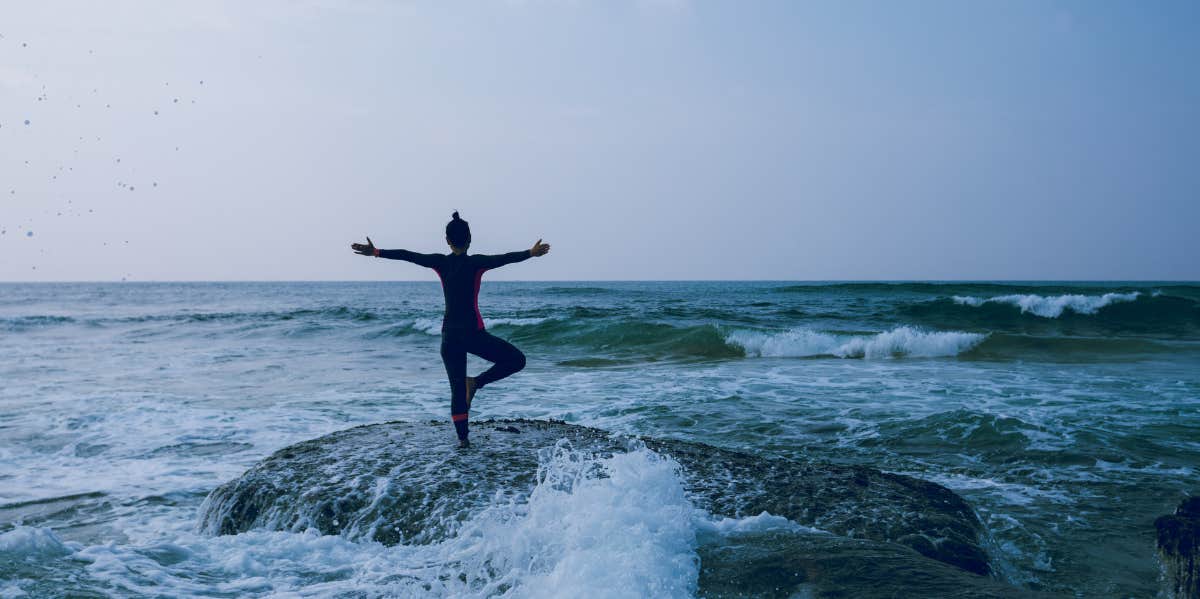 Woman exerting mental capability while doing yoga in the ocean