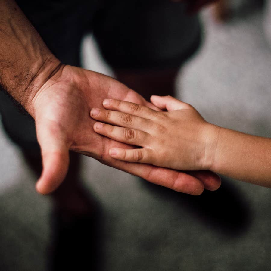 kids hand resting in man&#039;s hand