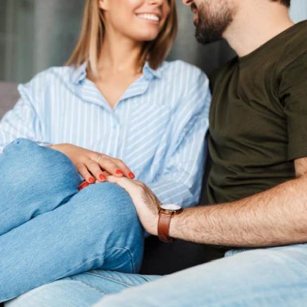 guy holding woman&#039;s hand on couch
