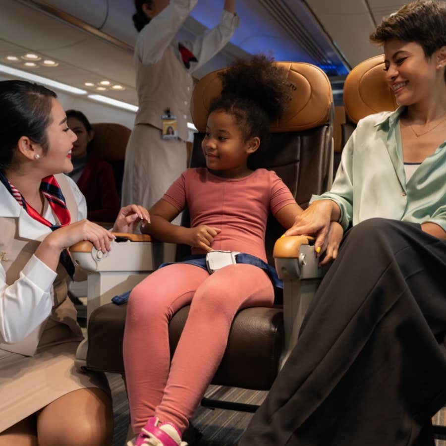 flight attendant speaking to little girl on plane