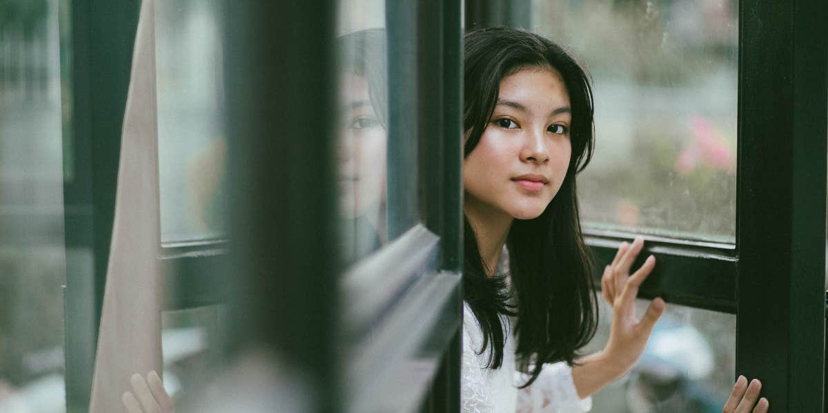 4 Reasons Your Toxic Ex Keeps Crawling Back To You woman opening the door curiously