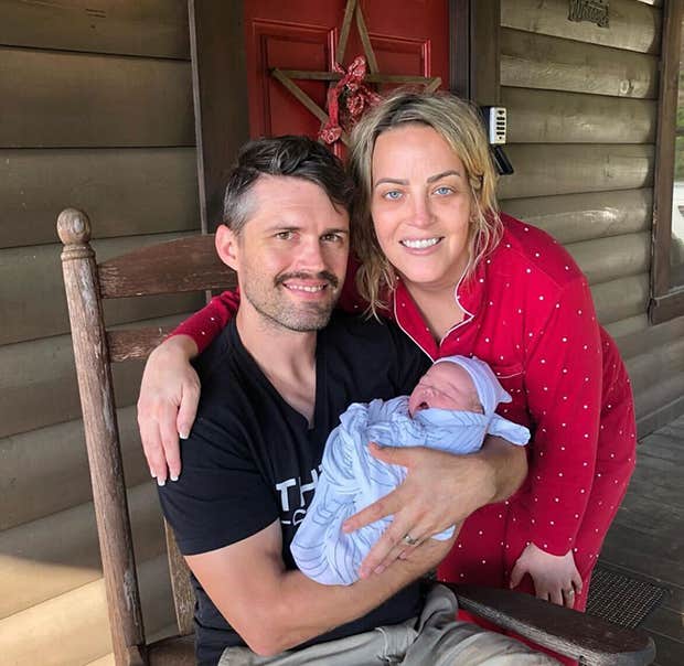 Lovable photo of Heather and her husband Austin smiling with their newly born baby