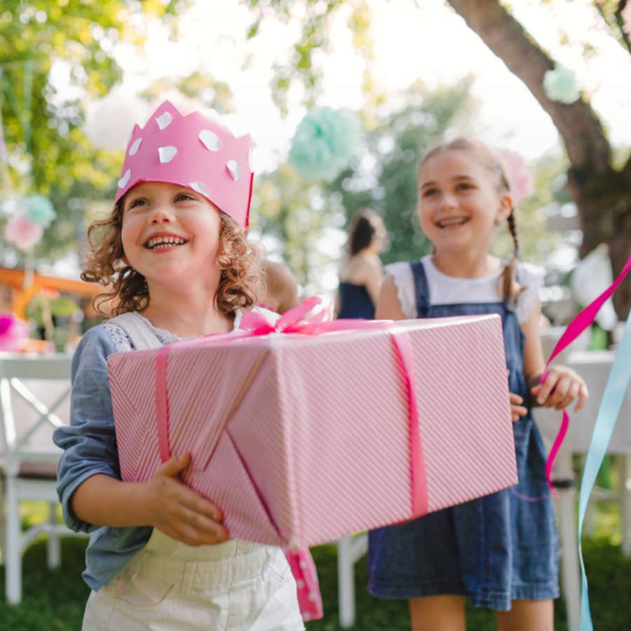 young girl holding birthday present at party