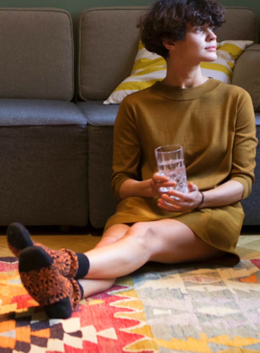 contemplative woman sits on floor