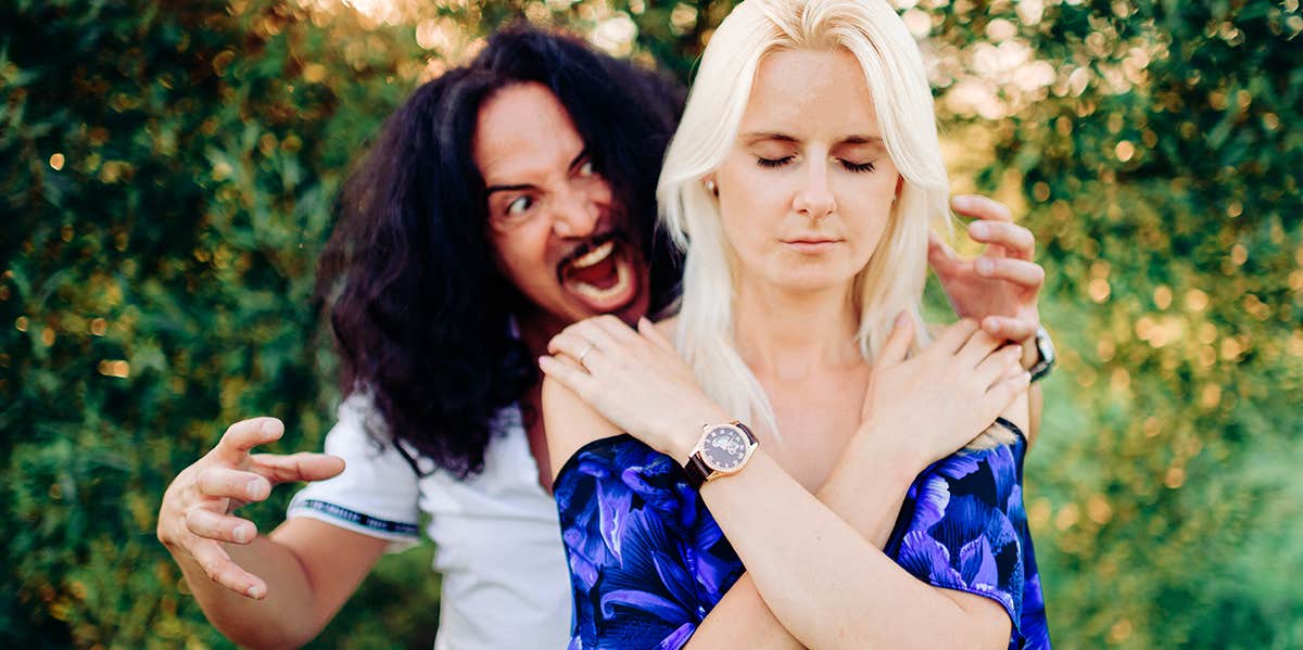 4 Techniques To Stop Your Spouse From Criticizing You (That Are So Effective It's Scary) man standing behind woman with annoyance woman in peace