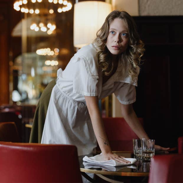 restaurant worker cleaning a table