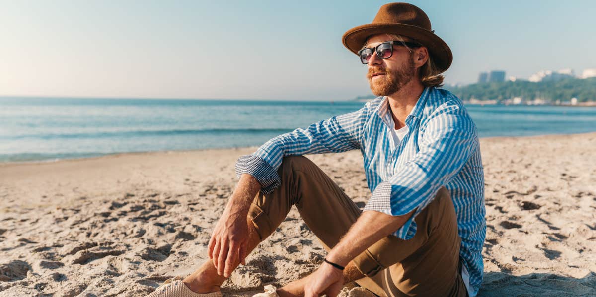 15 Men Reveal What They Secretly Do To Get Over Someone man sitting on beach soaking up the sun
