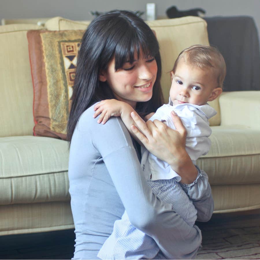 young woman smiling and hugging child