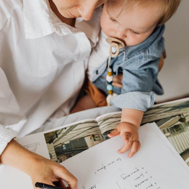 woman working while holding a baby