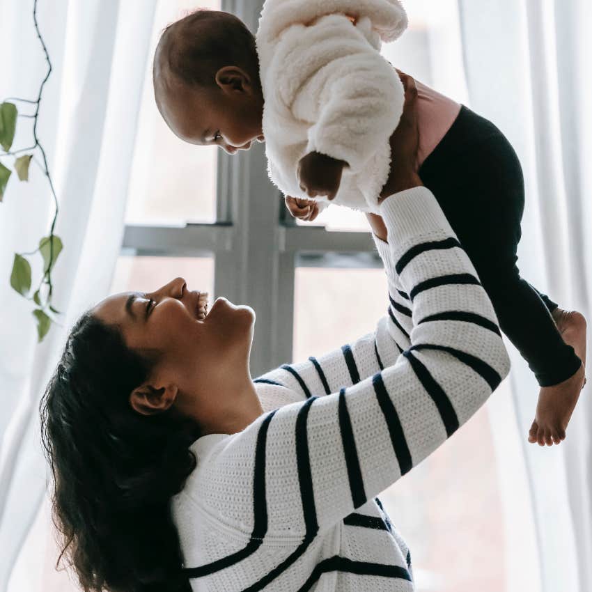 woman holding baby in the air