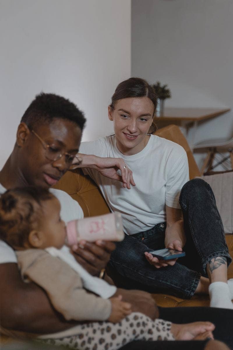 woman watching as baby feeds baby