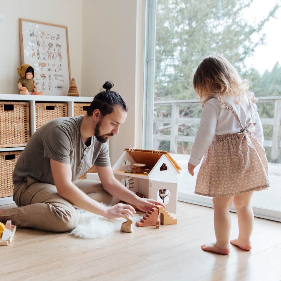 man sitting on the floor playing with toddler