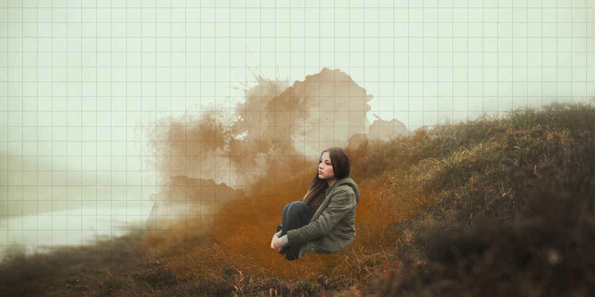 woman sitting alone on a foggy hill 
