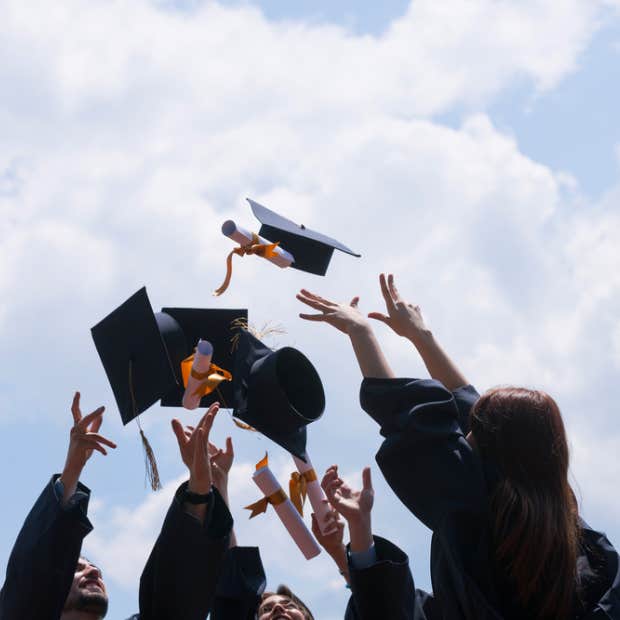 graduates tossing up their caps and diplomas