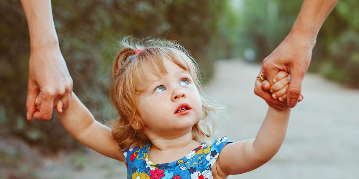 little girl holding parents hands