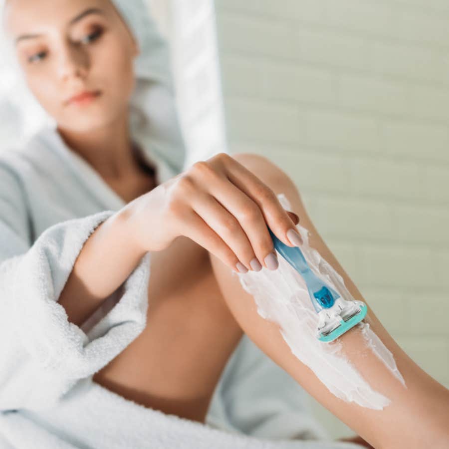 woman shaving her legs