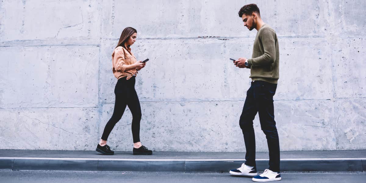 Young couple walking past each other, ignoring