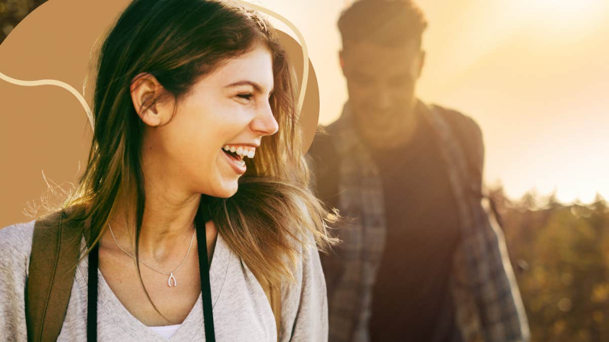 Happy couple hiking with the bright sun of the soul washing the image from behind