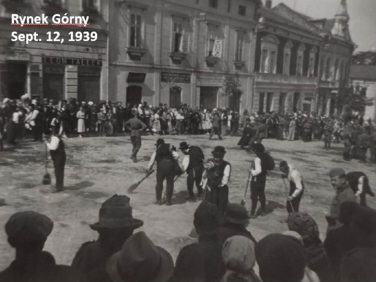 Observant Wieliczka Jews forced to sweep the upper city square on September 12, 1939, as the Germans supervised. From here 32 Jewish men were put on lorries, driven to a nearby forest and shot by the Germans. [Photo taken by unnamed Wehrmacht soldier on September 12, 1939; courtesy of Tomasz Wisniewski, Ph.D., Wisniewski Coll. www.bagnowka. pl; and http://www.belzec.eu/media/files/pages/278/wieliczka_ang.pdf]