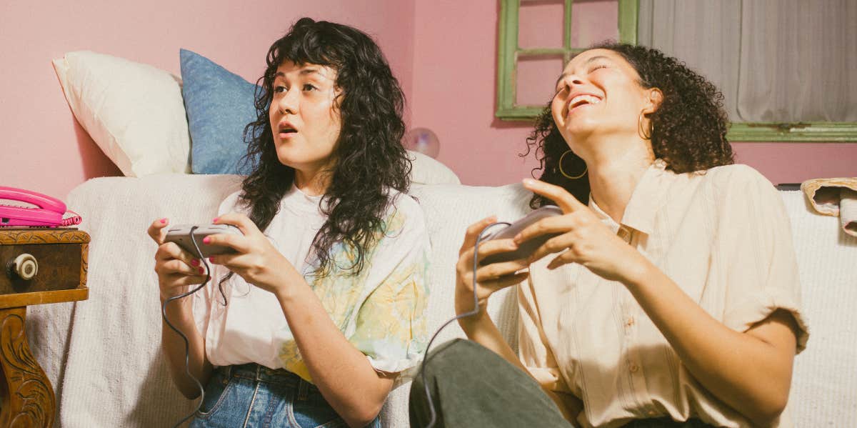 The 3 Soulmates You'll Meet In Your Lifetime (And The Purpose Of Each) best friends playing video games together, laughing.