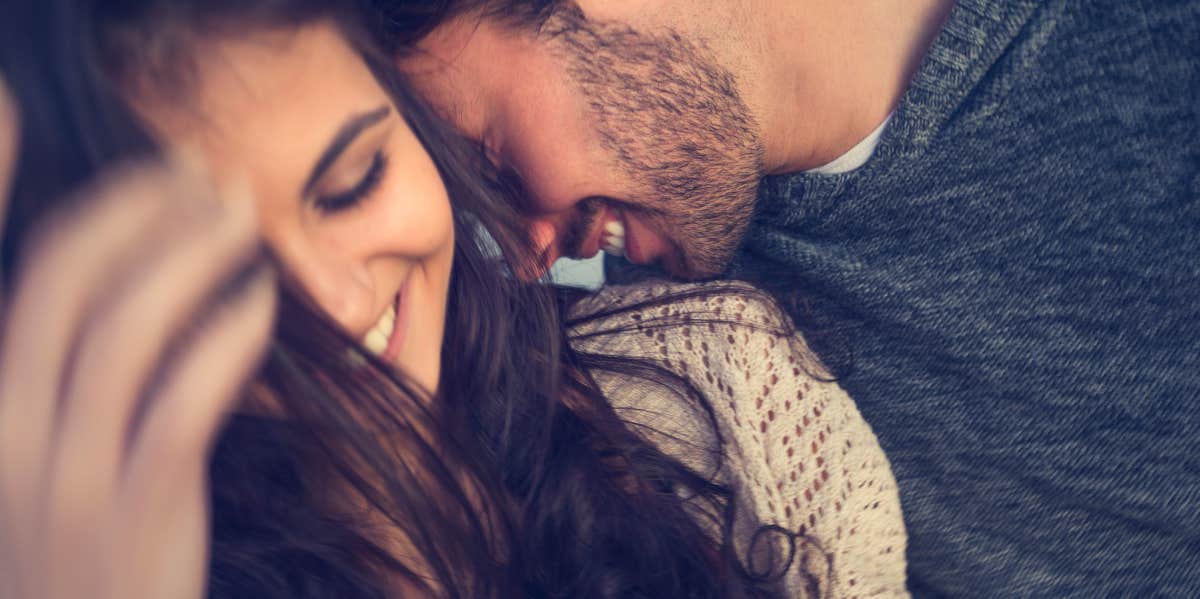 man kissing woman neck