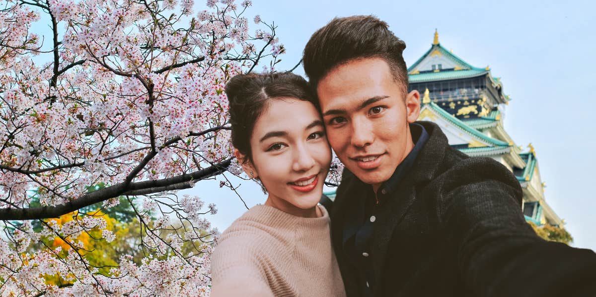 Japanese couple in front of cherry blossoms