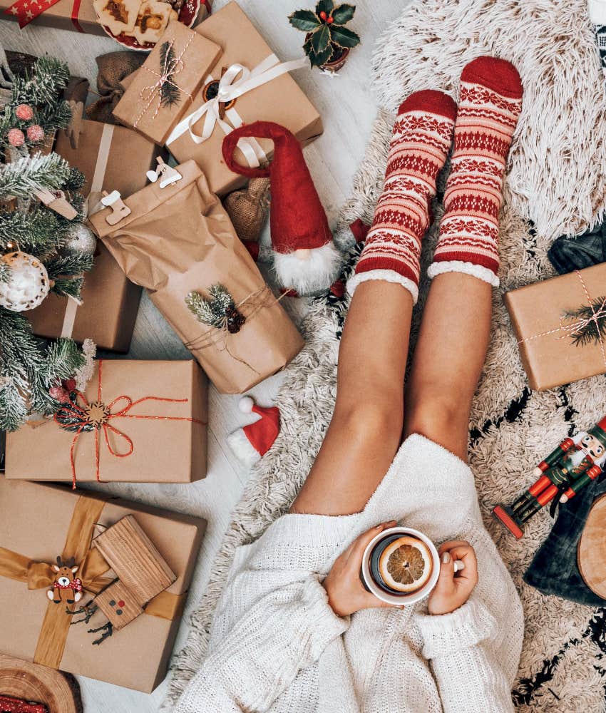 person in christmas socks surrounded by gifts