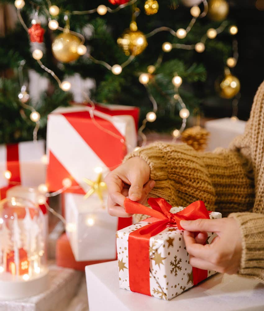 person wrapping a christmas present